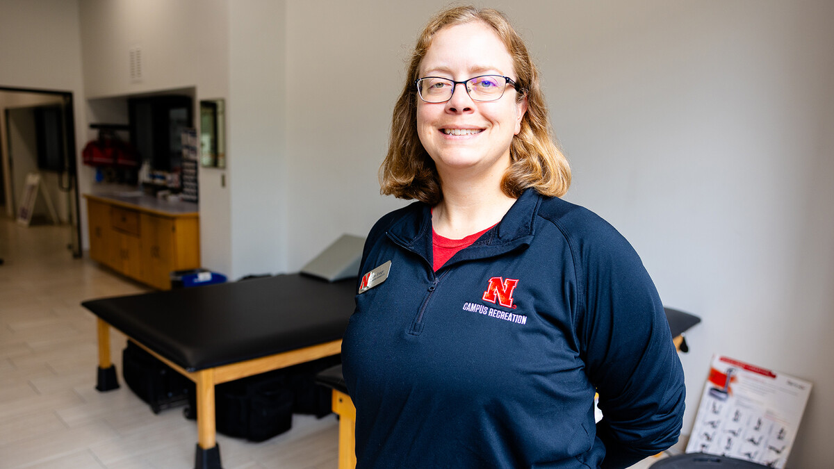 Jen Krueger, senior coordinator for injury prevention and care, stands in front of the large windows into the Injury Prevention and Care office on the second floor of the Campus Recreation Center. Krueger and her team treat injuries for rec center visitors and athletes, but also for dancers, members of the marching band and even campus guests.